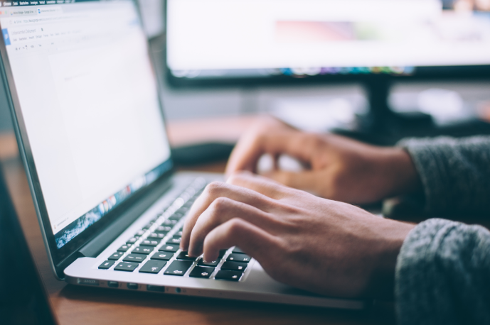 close up of hands typing on a laptop